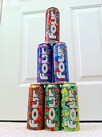 Six cans of four loko drinking beverage are arranged in pyramidal fashion.